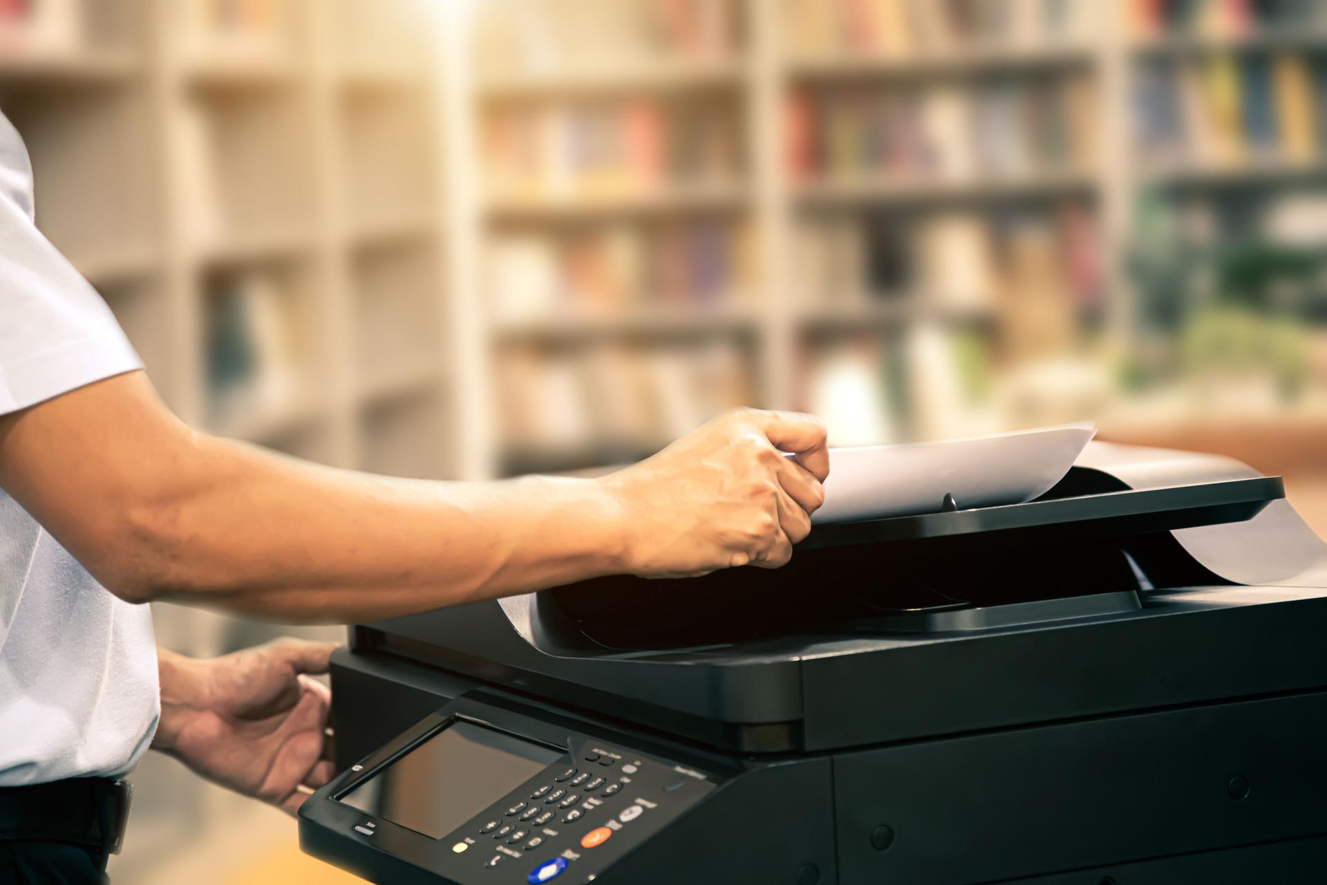 Copier printer, close up hand office man insert paper on panel to using the copier or photocopier machine for scanning document printing a sheet and xerox photocopy.