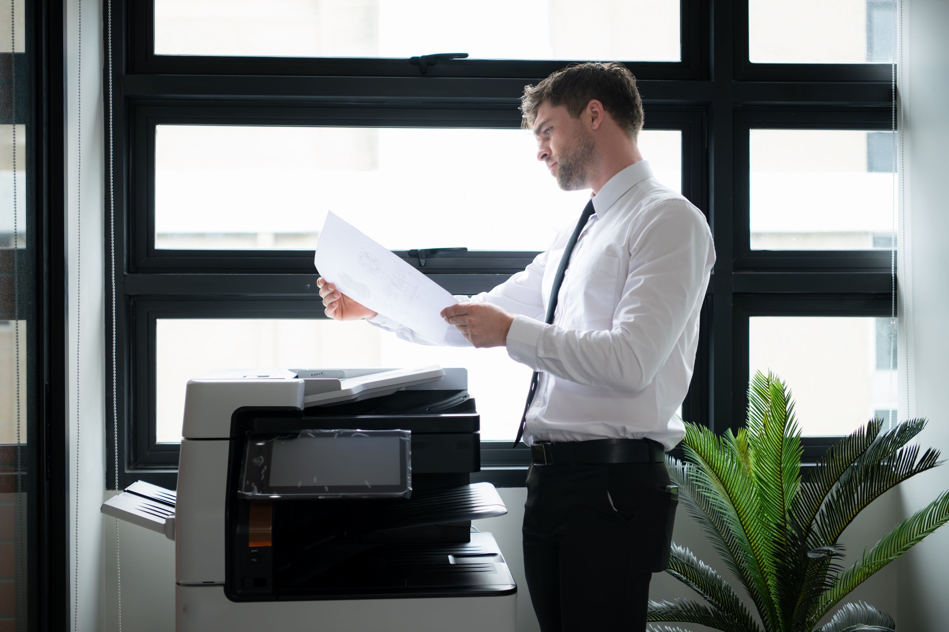 Businessman in office working with copier.